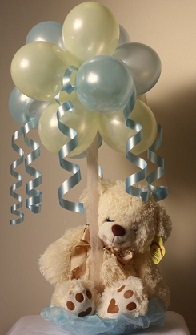 Two feet teddy grasping 10 Soft blue balloons on sticks with ribbons