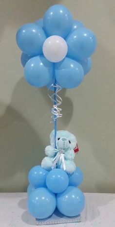 10 Blue Balloon bouquet tied to a basket with 6 inches Blue teddy sitting on 10 blue balloons