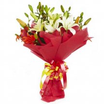 White lilies bouquet with red paper wrapping
