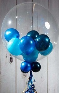Dark and Light Blue color small balloons inside a clear bobo balloon with 4 blue balloons and foliage trailing on stick
