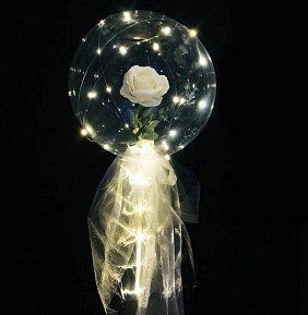 Single white rose in a clear balloon wrapped in white